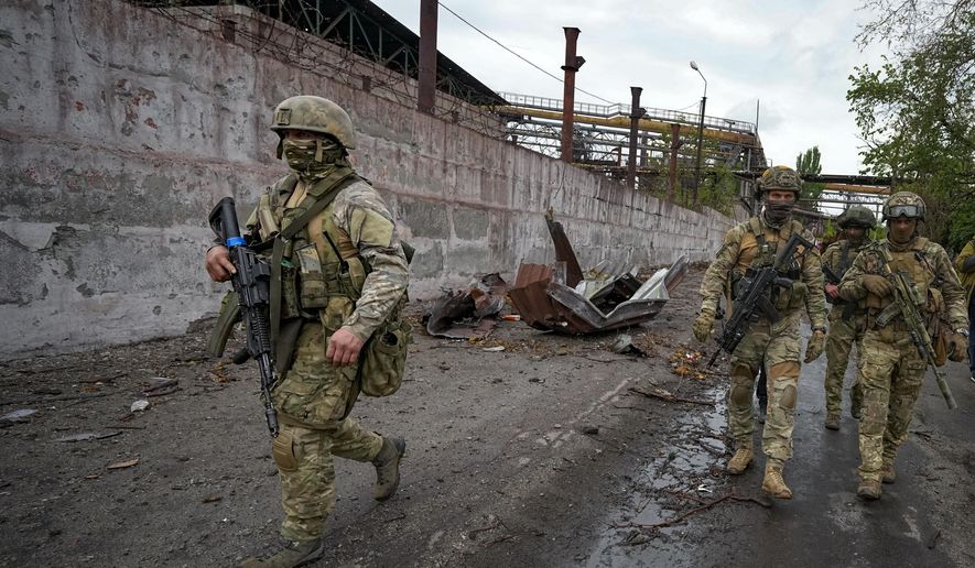 FILE - Russian soldiers patrol a destroyed part of the Illich Iron &amp;amp; Steel Works Metallurgical Plant in Mariupol, in territory under the government of the Donetsk People&#39;s Republic, eastern Ukraine, Wednesday, May 18, 2022. Despite getting bogged down in Ukraine, the Kremlin has resisted announcing a full-blown mobilization, a move that could prove to be very unpopular for President Vladimir Putin. That has led instead to a covert recruitment effort that includes trying to get prisoners to make up for the manpower shortage. This photo was taken during a trip organized by the Russian Ministry of Defense. (AP Photo, File)